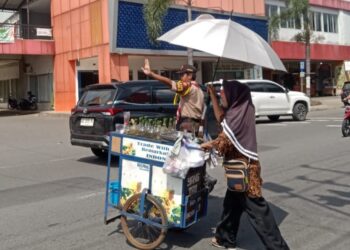 Pramuka Saka Bhayangkara Bantu Penjual Keliling di Pasar Ir. Soekarno