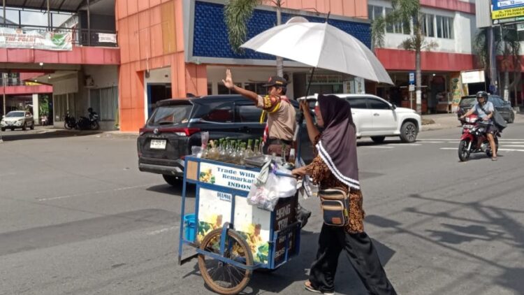 Pramuka Saka Bhayangkara Bantu Penjual Keliling di Pasar Ir. Soekarno